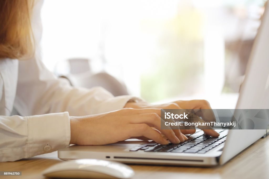 Close up woman working at home office hand on keyboard laptop. Adult Stock Photo