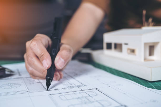 istock Closeup image of architects drawing shop drawing paper with mass model on table 881983810