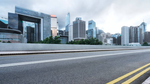 istock modern buildings and empty road against cloudy sky 882041646