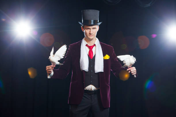 istock The magician with a two flying white Doves. on a black background 882046370