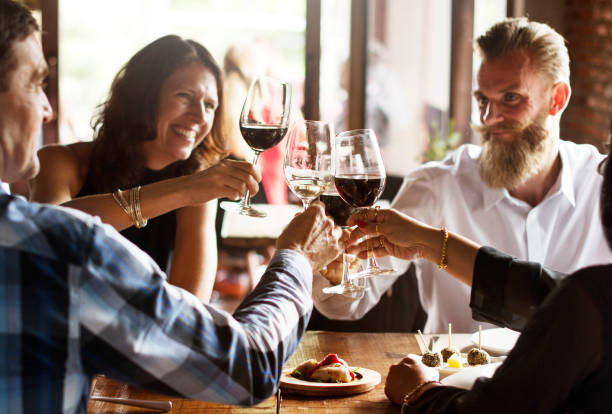 friends at a dinner party - wine dinner party drinking toast imagens e fotografias de stock