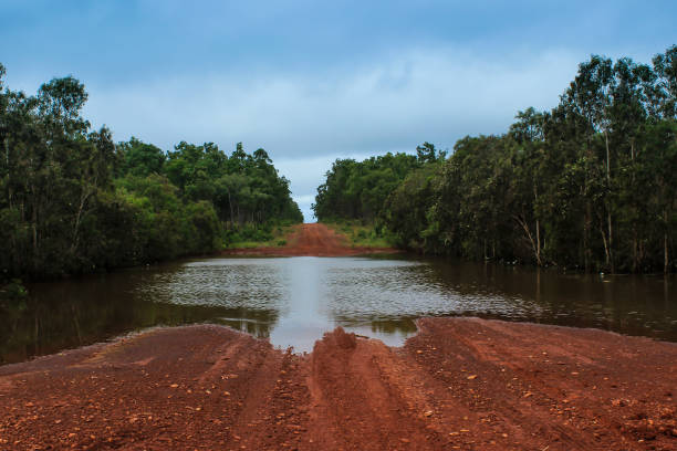 flood water across an unmade gravel road flood water across an unmade gravel road queensland floods stock pictures, royalty-free photos & images