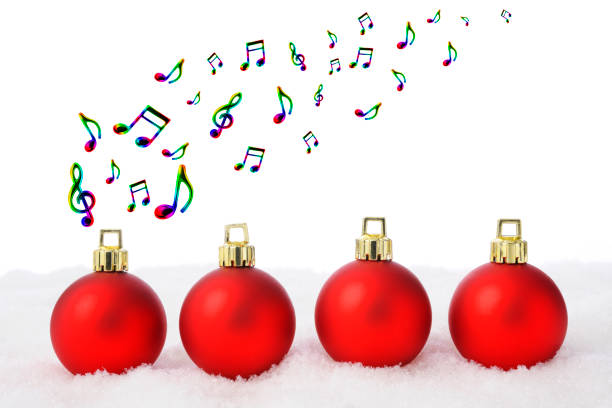 istock Four red Christmas ornaments on the snow, and flying multi colored musical note 882076234
