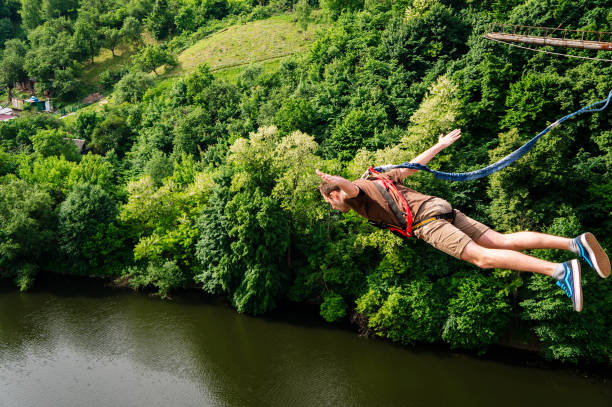 Extreme jump from a 42 m high pedestrian bridge Zhytomyr, Ukraine - May 30, 2015: Extreme jump from a 42 m high pedestrian bridge. Leap with a rope. bungee jumping stock pictures, royalty-free photos & images