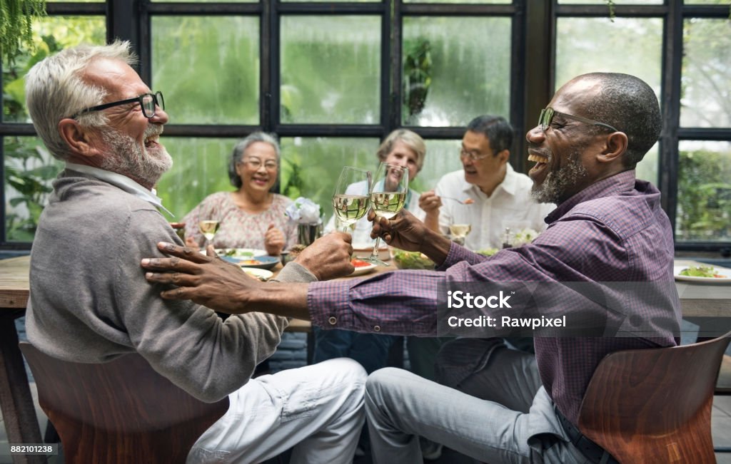 Mature friends at a dinner party Senior Adult Stock Photo