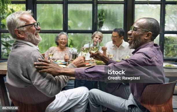 Mature Friends At A Dinner Party Stock Photo - Download Image Now - Senior Adult, Friendship, Dinner