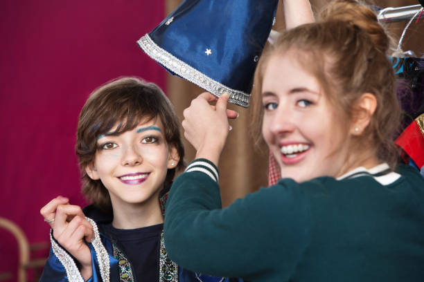 istock Theater assistant helps student dress as wizard 882111876