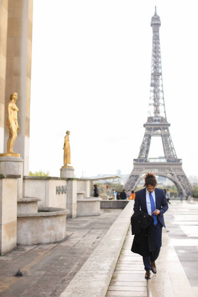 istock Hispanic businessman calling partner with phone near Eiffel Towe 882112094