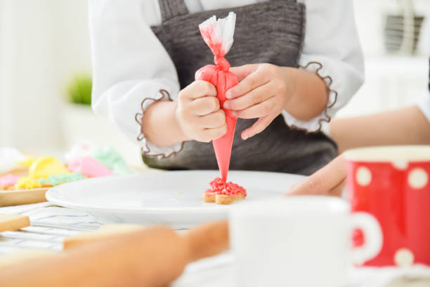 istock Happy Asian Kid decorating cookies. 882115756
