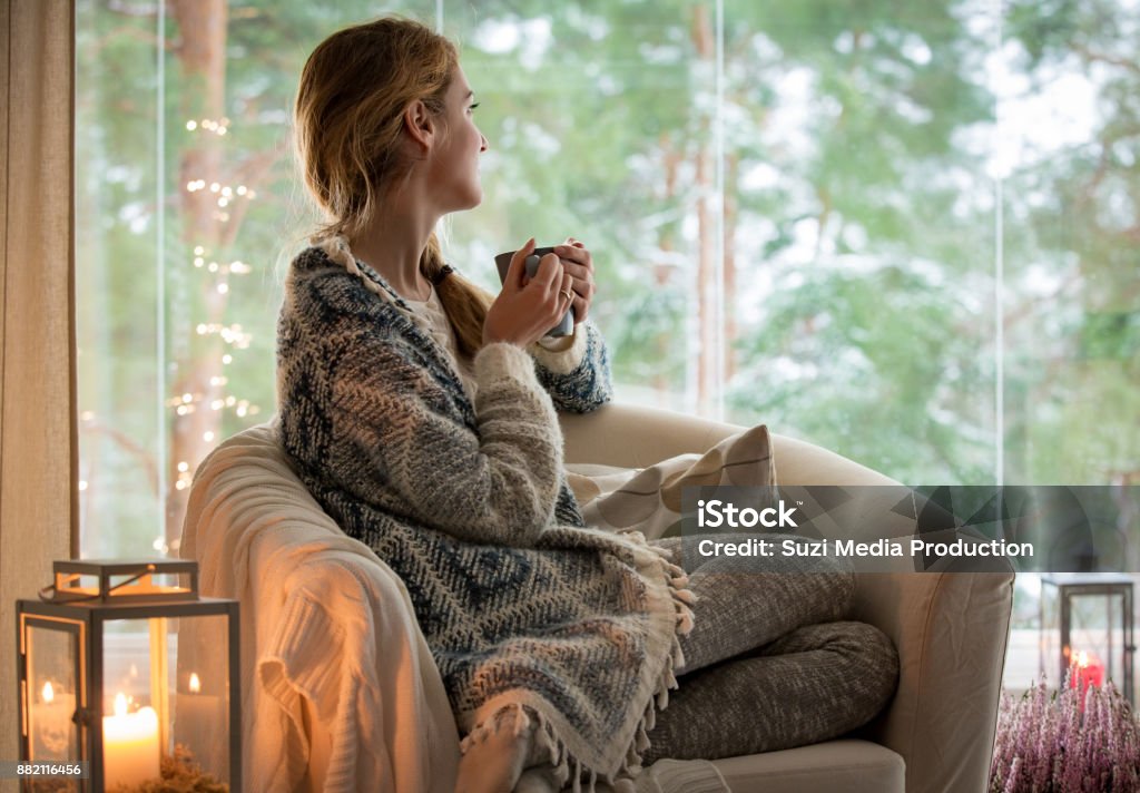 Jonge vrouw thuis te zitten bij het raam - Royalty-free Huiselijk leven Stockfoto