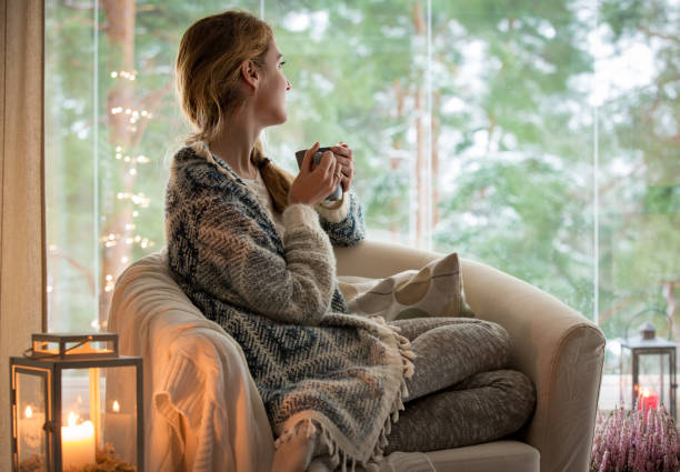 istock Young woman sitting home by the window 882116456