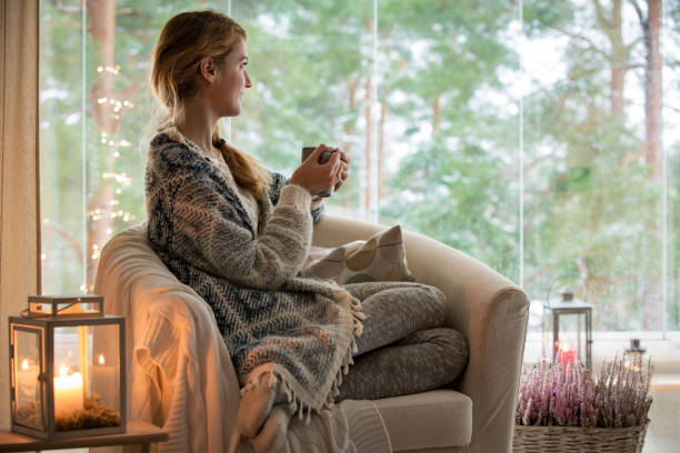 istock Young woman sitting home by the window 882116514