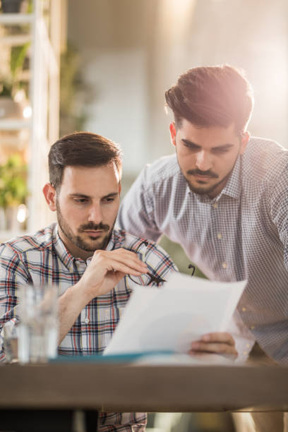 istock Two entrepreneurs reading their business documents in the office. 882125406