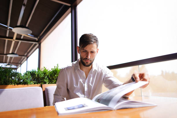 istock Art director and designer watching new magazine at cafe table 882131852
