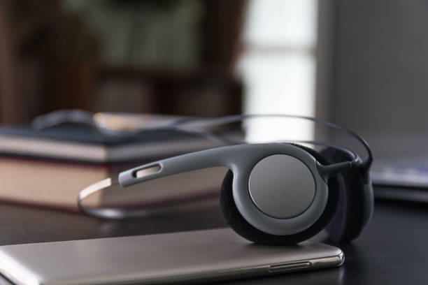 istock Headphones with book and mobile phone on wood table 882138134