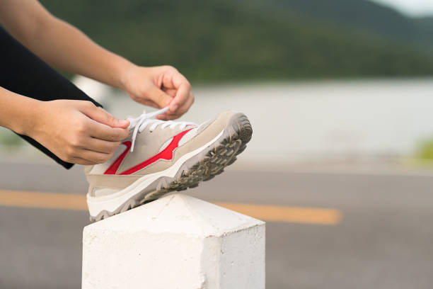 istock Woman tying shoelace his before starting running 882138172