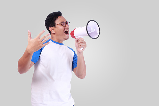 Businessman shaking fist and screaming into megaphone