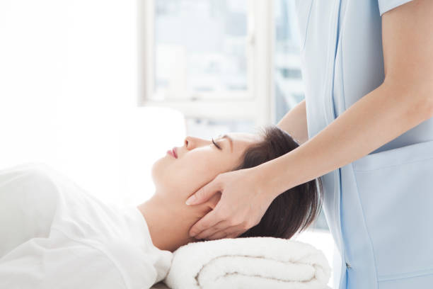 a woman undergoing a treatment of his head. - shoulder bone imagens e fotografias de stock