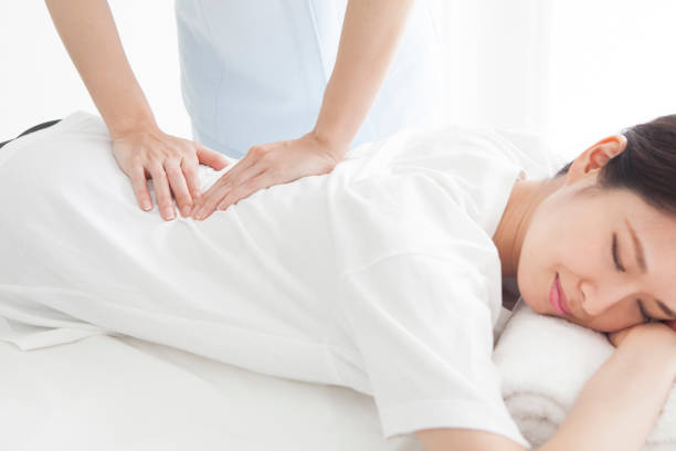 une femme qui a subi une chirurgie de taille allongée sur son visage. - torso physical therapy patient relaxation exercise photos et images de collection