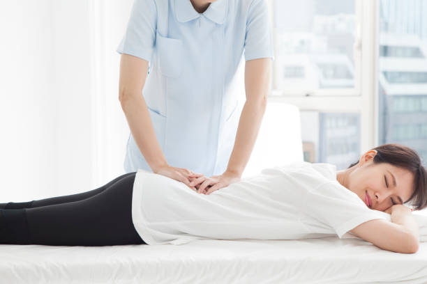 une femme qui a subi une chirurgie de taille allongée sur son visage. - torso physical therapy patient relaxation exercise photos et images de collection