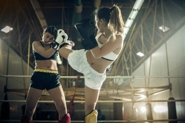 istock Determined female boxers fighting on a kickboxing match in a ring. 882144076