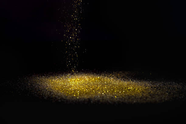 istock Sprinkle glitter gold dust on a black background with copy space 882155728