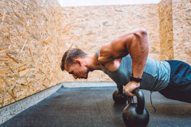 istock Muscular male athlete training arms with kettlebells 882155746