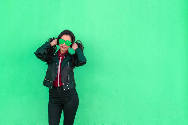 young woman with colorful glasses pulling her hair on green background - funky contemporary casual sex symbol imagens e fotografias de stock