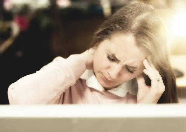 Photo of Headache distresses brightly lit woman office worker rubbing her neck