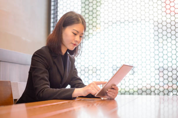 istock young businesswoman using tablet PC in cafe 882175994
