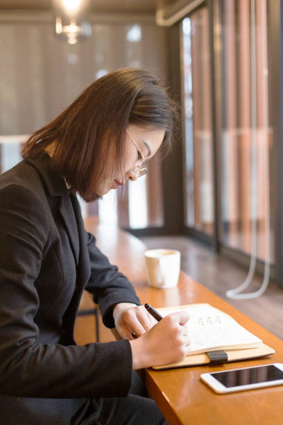 istock business woman making notes at table in cafe 882179480