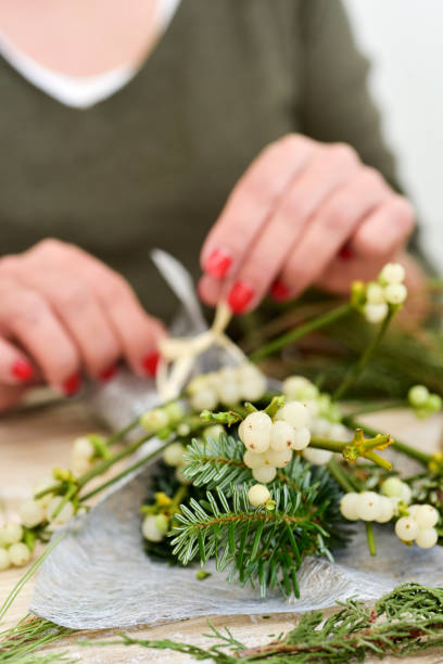 istock woman arranging a bunch of mistletoe 882208532