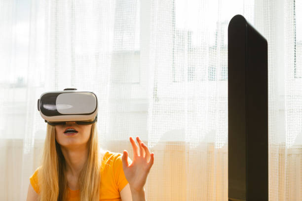 istock Girl wearing virtual reality goggles at home 882215332