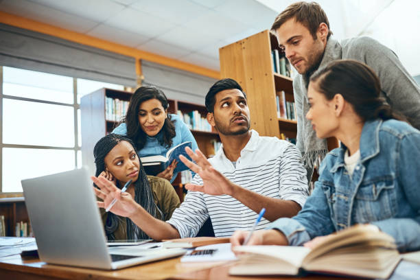 He's a great tutor Cropped shot of a group of university students studying in the library final round stock pictures, royalty-free photos & images