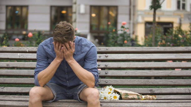 istock Upset young man sitting on bench alone, closing face with hands, break-up 882215858