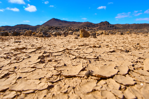 Dry desert in Malpaís Grande, clay chips and volcanic stones in MAlpaís Grande, Fuerteventura volcanic desertic landscape.