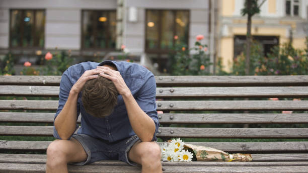 istock Desperate young man sitting alone on bench, suffering depression after break-up 882215898