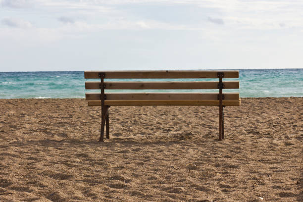 istock A lonely bench on an empty beach near blue sea 882216158