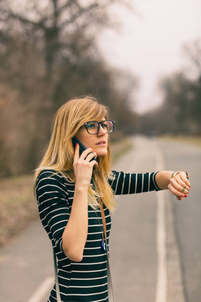 istock Modern beautiful woman talkingon her cellphone while checking the time on her wrist watch outdoors. 882223604