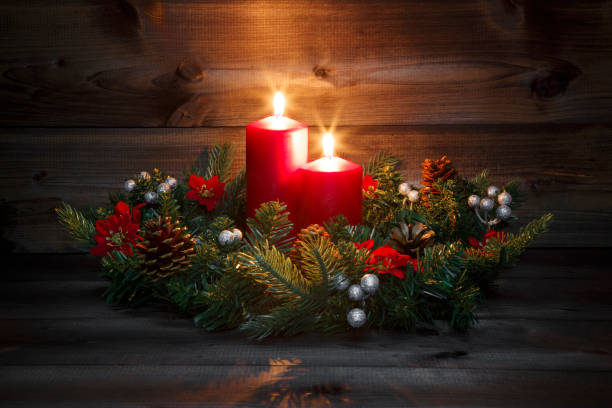 istock Second Advent - Decorated Advent wreath with two red burning candles on a wooden background with festive atmosphere 882226234