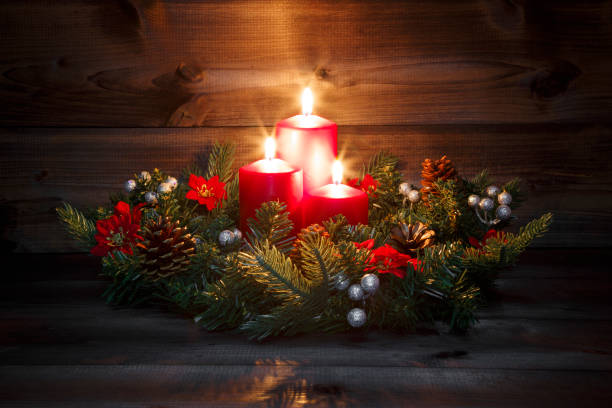 istock Third Advent - Decorated Advent wreath with three red burning candles on a wooden background with festive atmosphere 882226306