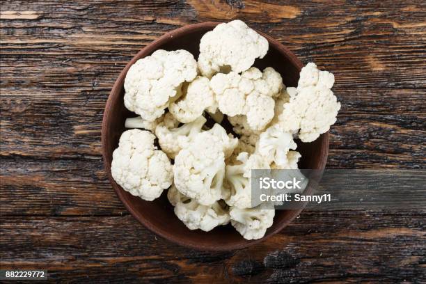 Useful Cauliflower In A Clay Plate On A Wooden Table In The Kitchen Top View Stock Photo - Download Image Now