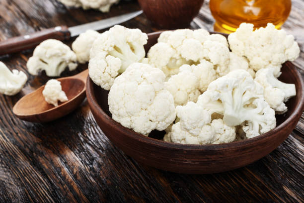istock Useful cauliflower in a clay plate on a wooden table in the kitchen. top view 882232194