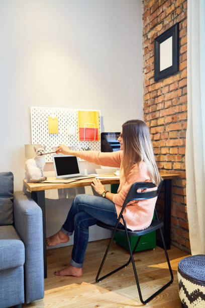 istock Young woman playing pencil with her cat 882235616