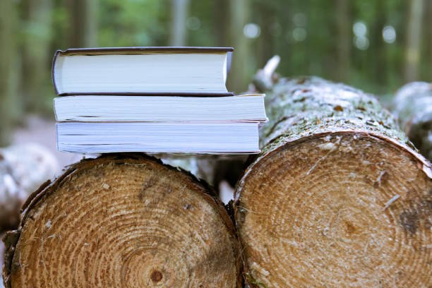 istock A stack of books lying on felled trees,  save trees - read ebooks 882245994