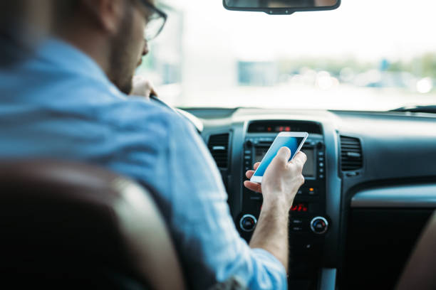 uomo che usa il telefono durante la guida dell'auto - distracted foto e immagini stock