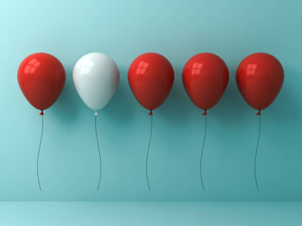 istock Stand out from the crowd and different concept , One white balloon different from other red balloons on light cyan pastel color wall background with reflections and shadows 882246478