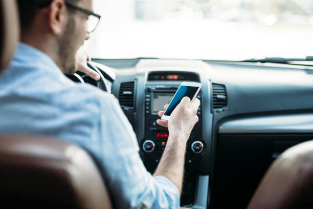 istock Businessman ignoring safety and texting on mobile phone while driving 882246530