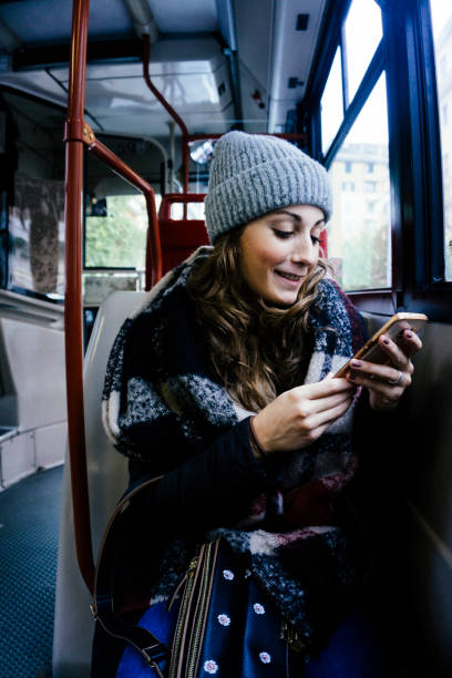 istock Young happy woman using the phone on a bus 882250532