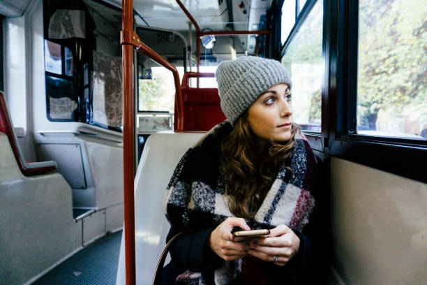 istock Young happy woman using the phone on a bus 882254884